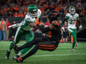 Le secondeur des Roughriders de la Saskatchewan, Derrick Moncrief (42 ans), s'attaque au receveur des Lions de la Colombie-Britannique Dominique Rhymes (19 ans) alors qu'il complète une passe au cours de la deuxième moitié du match de football de la LCF à Vancouver, vendredi.