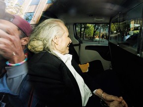 Vu à travers la vitre d'un véhicule de police, le magnat de la mode canado-finlandais Peter Nygard quitte un palais de justice à Toronto le 26 septembre 2023. Nygard, 82 ans, est jugé pour des accusations d'agression sexuelle et de séquestration datant des années 1980.