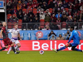 Le milieu de terrain du Toronto FC Michael Bradley (4) regarde l'attaquant d'Orlando City Duncan McGuire (13) marquer le gardien de Toronto Sean Johnson (1) lors de la deuxième mi-temps de l'action MLS à Toronto, le samedi 21 octobre 2023.