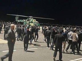 Des gens dans la foule crient des slogans antisémites sur un aérodrome de l'aéroport de Makhachkala, en Russie, le lundi 30 octobre 2023.