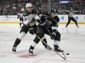 Le défenseur des Coyotes de l'Arizona Travis Dermott (33 ans) défend contre le centre des Kings de Los Angeles Quinton Byfield (55 ans) pendant la deuxième période d'un match de hockey de la LNH, le mardi 24 octobre 2023, à Los Angeles.