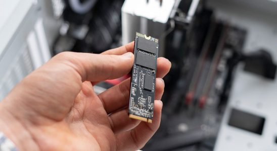 person holding new modern fast ssd m2 drive to replace it on computer