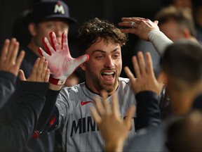 Edouard Julien, des coéquipiers des Twins du Minnesota, fait un high-five.