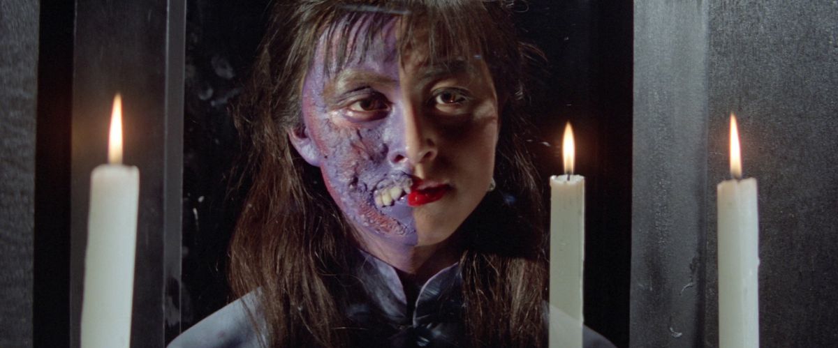 Une femme vampire avec un visage humain normal et demi avec une peau violette et des dents à crocs de Encounters of the Spooky Kind