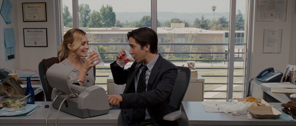 Justin Long et Alison Lohman trinquent derrière un bureau dans Drag Me to Hell