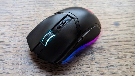 Test Razer Cobra Pro : une souris noire avec RGB multicolore apparaît sur une surface en bois.