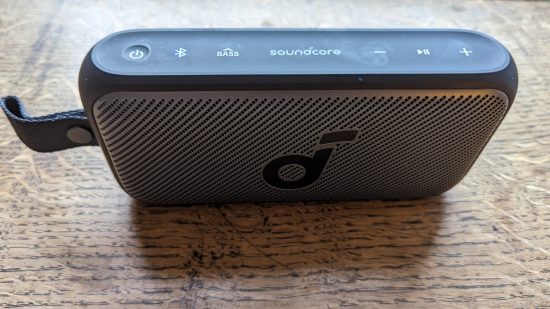 Test Anker Soundcore Motion 300 : un haut-parleur noir avec grille argentée apparaît sur une surface en bois.