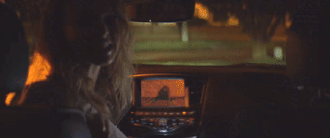 Un gif de Heather Graham au volant d'une mini-fourgonnette, reculant et heurtant un homme ensanglanté vu uniquement dans sa caméra de recul, tiré du film d'horreur Adapté Flesh