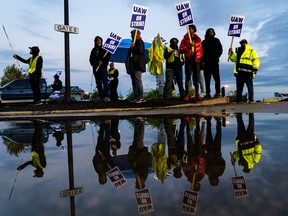 Les ouvriers d'usine et les membres du syndicat UAW forment une ligne de piquetage devant l'usine de camions Ford Motor Co. Kentucky le 14 octobre. Corrigés de l'inflation, les salaires horaires des trois constructeurs automobiles de Détroit sont inférieurs à ceux des décennies précédentes.