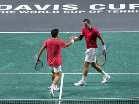 Vasek Pospisil du Canada, à droite, et Alexis Galarneau du Canada réagissent après avoir remporté un point contre Harri Heliovaara de Finlande et Patrik Niklas-Salminen de Finlande lors d'un match de tennis quart de finale de la Coupe Davis entre le Canada et la Finlande à Malaga, en Espagne, le mardi 21 novembre 2023.