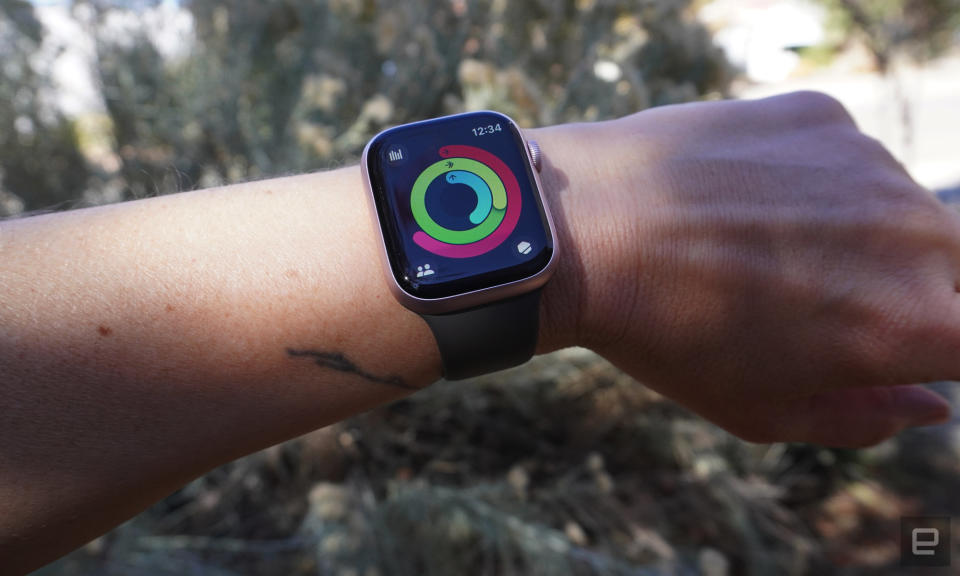 Une personne porte l'Apple Watch qui affiche l'application d'activité et les anneaux de fitness.  