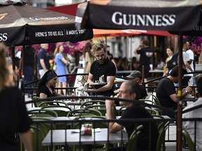 Un serveur travaille sur la terrasse d'un pub du marché By à Ottawa, le vendredi 23 juin 2023.