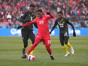 Jonathan David, du Canada, s'éloigne de Richard King (à gauche) et Devon Williams, de la Jamaïque, lors de la première moitié de la qualification pour la Coupe du monde de football de la CONCACAF, à Toronto, le dimanche 27 mars 2022. David a marqué lors de la victoire 2-1 du Canada contre la Jamaïque, samedi à Kingston, en Jamaïque. .