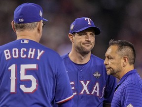 Le lanceur partant des Texas Rangers Max Scherzer quitte le match avec l'entraîneur sportif en chef Matt Lucero contre les Diamondbacks de l'Arizona lors de la quatrième manche du troisième match de la Série mondiale de baseball, le lundi 30 octobre 2023, à Phoenix.