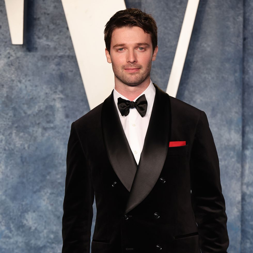 Patrick Schwarzenegger dans un costume noir et blanc sur un tapis rouge