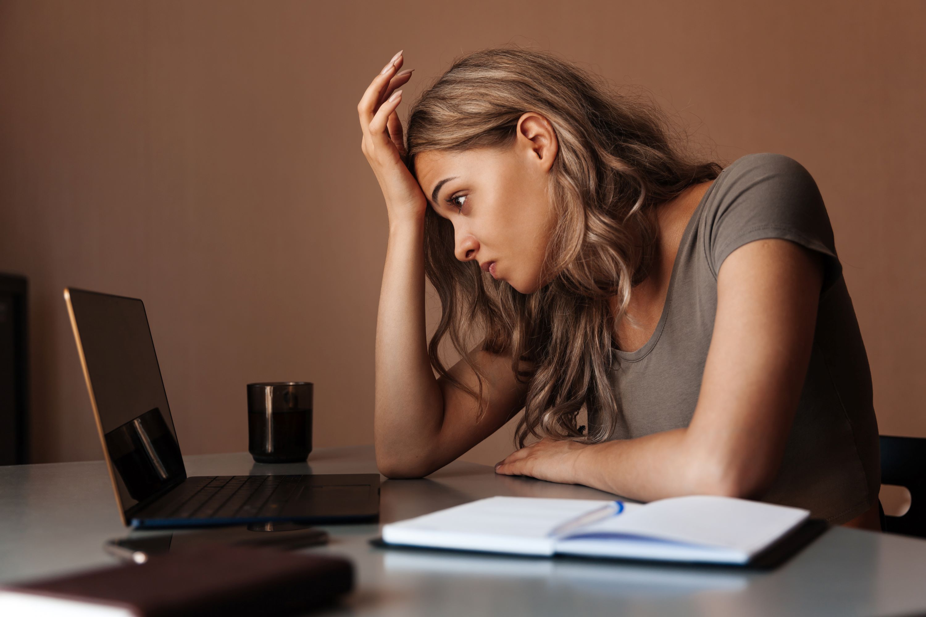 Femme fatiguée travaillant sur un ordinateur portable à la maison