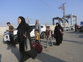 Des Palestiniens attendent au poste frontière entre la bande de Gaza et l'Égypte à Rafah, le mercredi 1er novembre 2023. Un Canadien qui tente de sortir de Gaza avec sa famille affirme qu'Affaires mondiales Canada lui a demandé de rassembler ses documents et de se préparer à partir. à tout moment par le poste frontière de l'enclave avec l'Égypte.