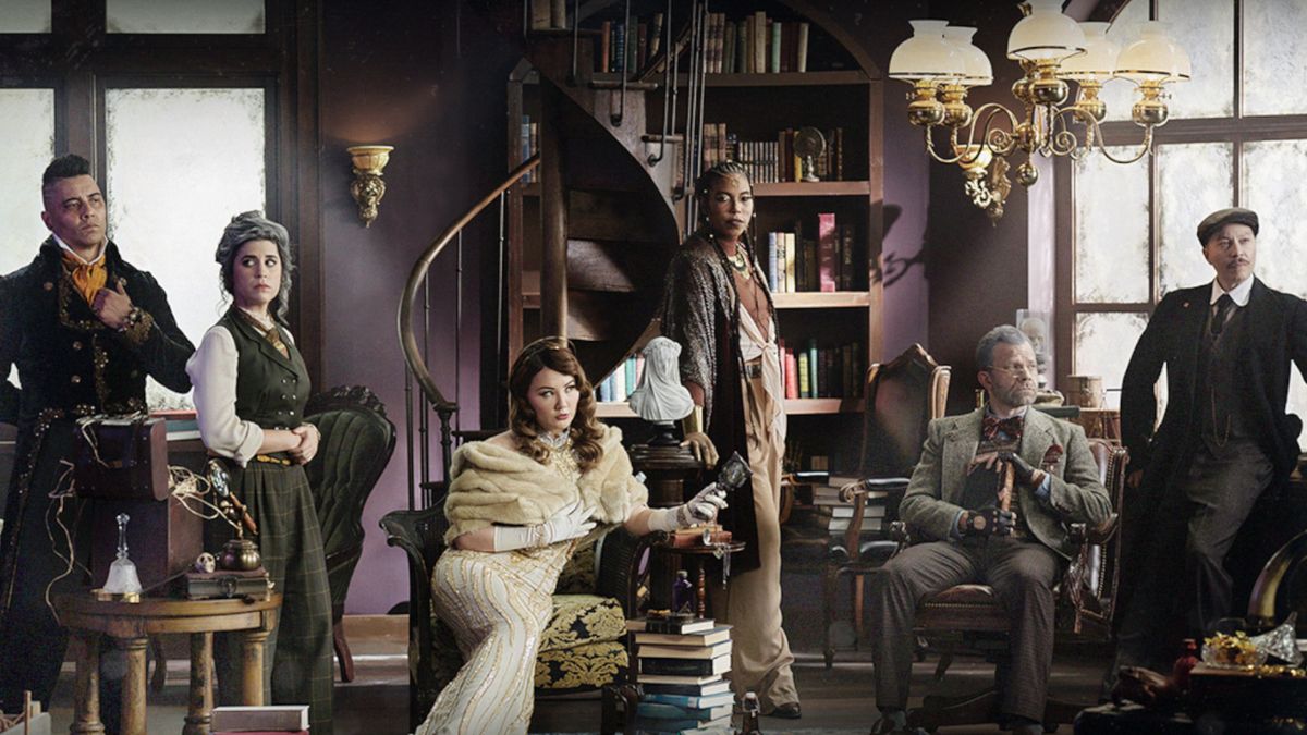 The cast of episode three of Candela Obscura, sat on 1920s chairs or standing around the room