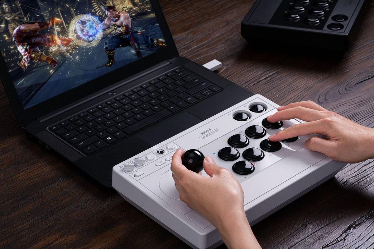 Une image de stock du stick 8Bitdo Arcade utilisé sans fil avec un ordinateur portable