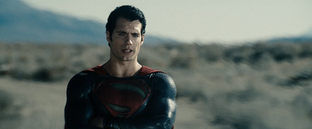 Henry Cavill croise les bras en parlant avec un front plissé dans Man of Steel.