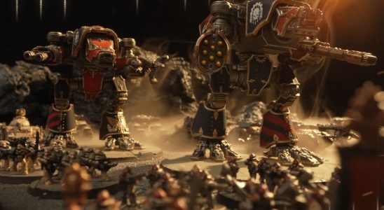 An array of miniature Space Marines and mechs march across an arid battlefield