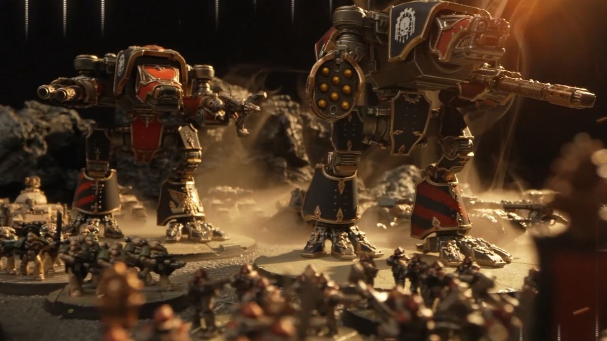 An array of miniature Space Marines and mechs march across an arid battlefield