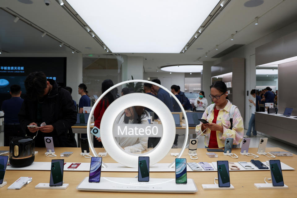 Les gens regardent les smartphones de la série Huawei Mate 60 exposés dans un magasin phare de Huawei à Pékin, en Chine, le 25 septembre 2023. REUTERS/Florence Lo