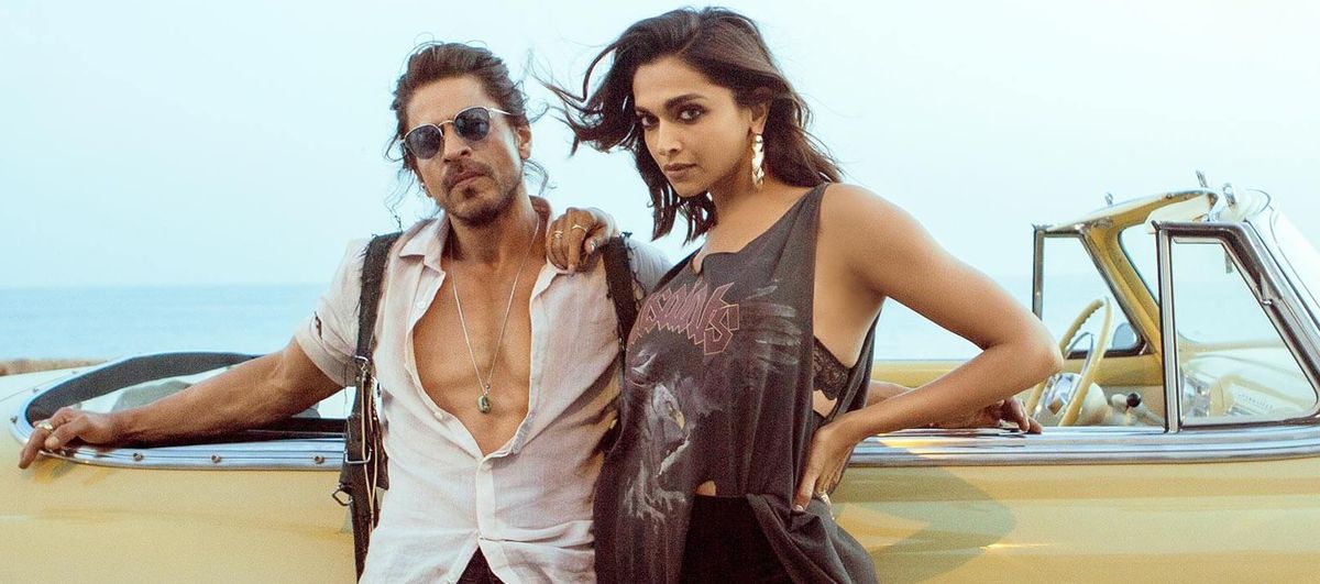 Shah Rukh Khan et Deepika Padukone s'appuient contre une décapotable jaune tout en ayant l'air incroyablement sexy à Pathaan.  On dirait qu'ils vous ont vu de l'autre côté du bar et qu'ils ont apprécié votre ambiance.