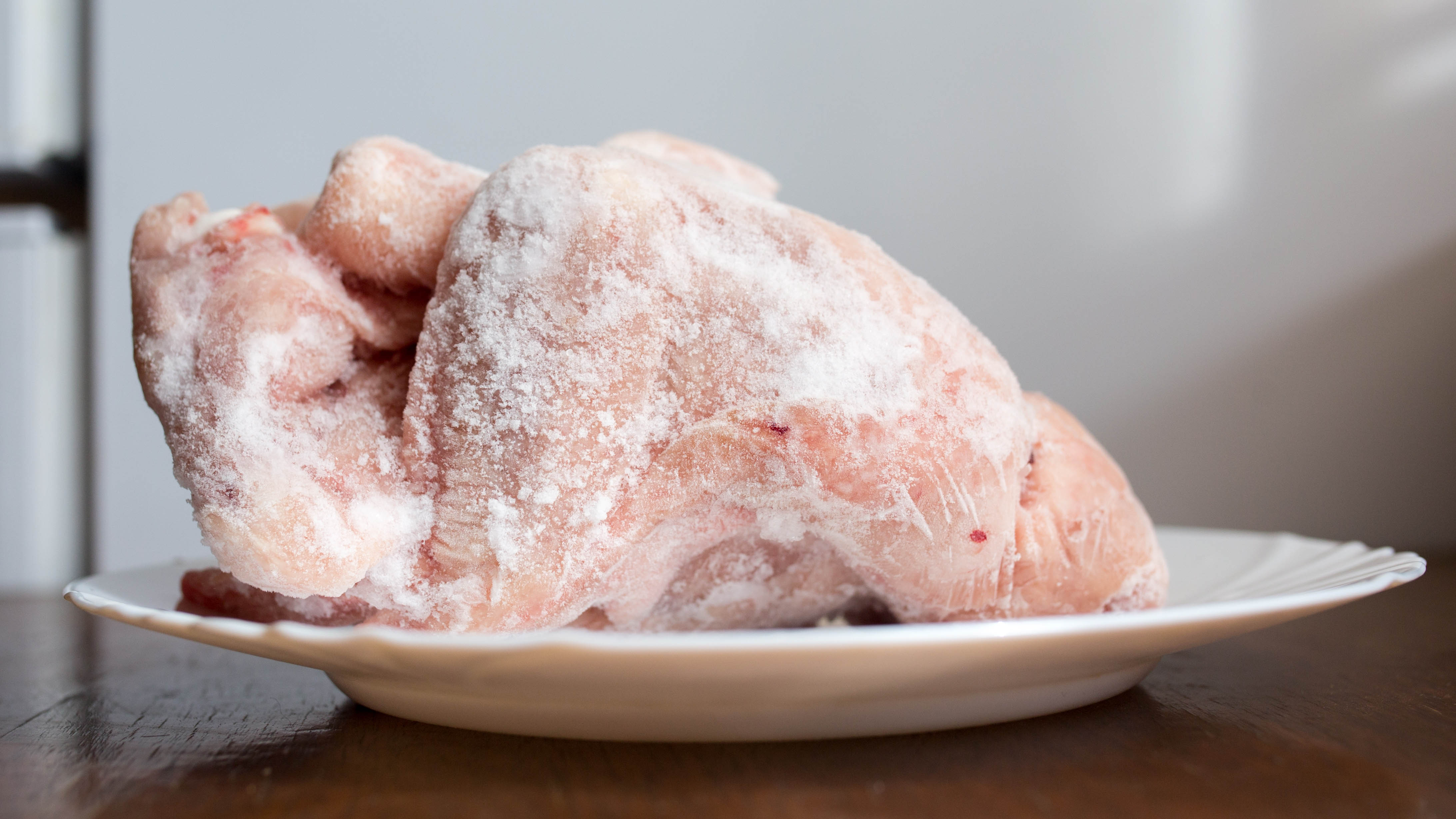 Un poulet entier décongelé dans une assiette