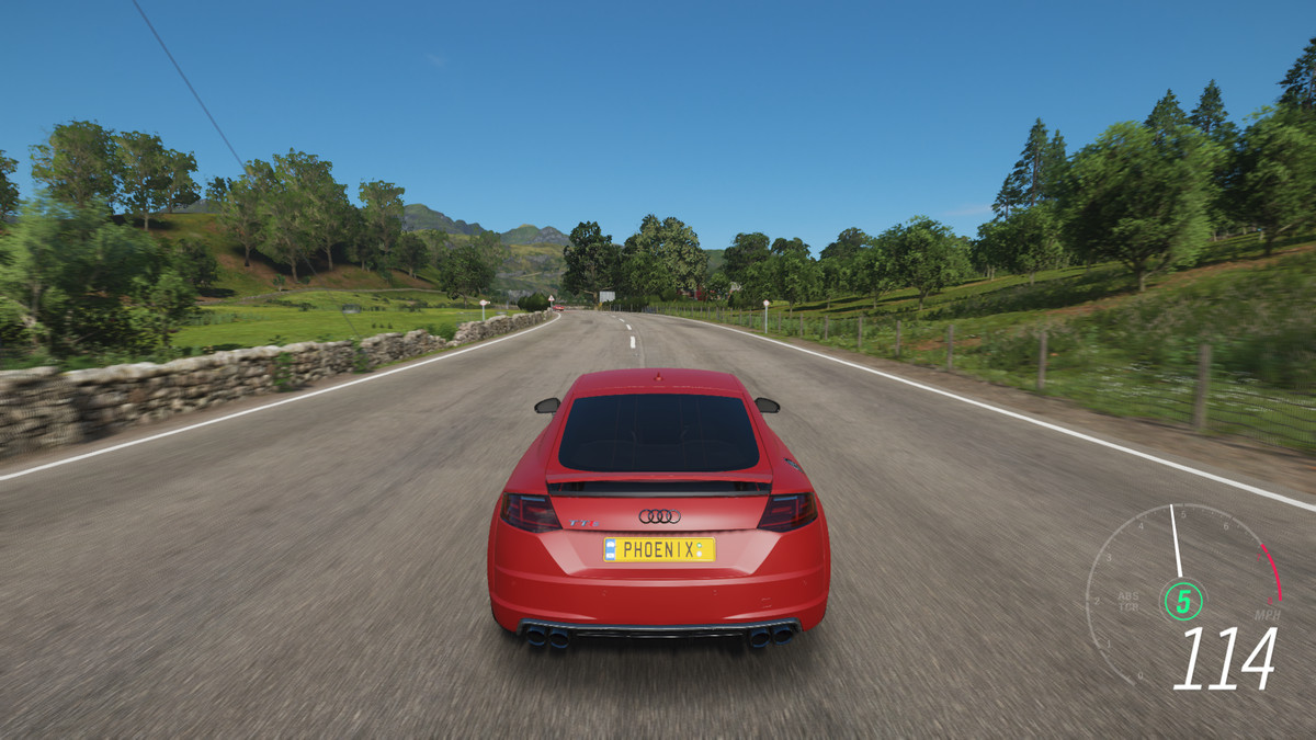 Une voiture rouge fonce sur une route pavée dans Forza Horizon 4