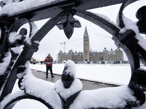 Un travailleur prépare un sentier sur la colline du Parlement à la suite d'une chute de neige, à Ottawa, le lundi 4 décembre 2023. Le gouvernement fédéral devrait dépenser davantage dans les soins de santé, une stratégie de logement et des initiatives en matière d'inflation et de coût de la vie - et geler ou réduire les dépenses ailleurs, selon un nouveau sondage.LA PRESSE CANADIENNE/Adrian Wyld