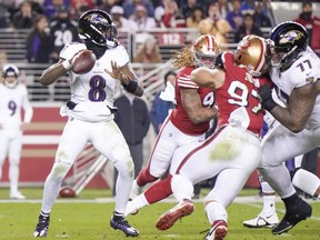 Lamar Jackson, à gauche, des Ravens de Baltimore, tente une passe contre les 49ers de San Francisco au cours du quatrième quart-temps au Levi's Stadium, le 25 décembre 2023 à Santa Clara, en Californie.