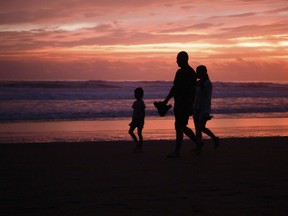 Des gens marchent sur la plage de Lazaro Cardenas, au Mexique, le dimanche 24 octobre 2021.