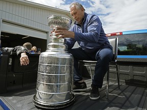 L'entraîneur-chef des Blues de St. Louis, Craig Berube, porte la coupe Stanley lors d'un défilé dans le hameau de Calahoo, en Alberta, le 2 juillet 2019.