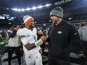 Le quart-arrière des Dolphins de Miami Tua Tagovailoa (1) interagit avec le quart-arrière des Jets de New York Aaron Rodgers (8) après la victoire de l'équipe contre les Jets de New York lors d'un match de football de la NFL le vendredi 24 novembre 2023, à East Rutherford, NJ