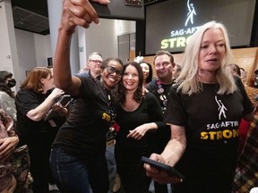 La présidente de la SAG-AFTRA, Fran Drescher, prend un selfie avec un membre du comité de négociation TV/théâtre en célébration après une conférence de presse dans les bureaux de la SAG-AFTRA à Los Angeles le vendredi 10 novembre 2023.