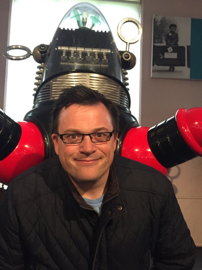 Un portrait photo de Nick Roberts devant le robot de Lost in Space.