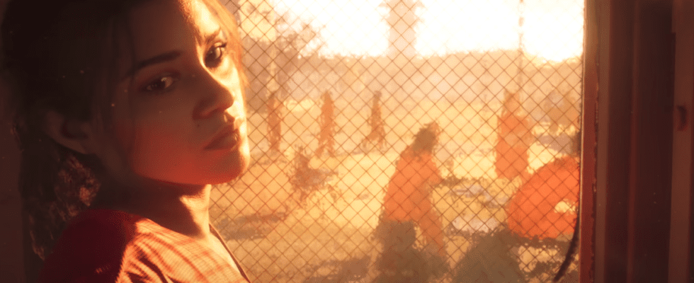 Lucia, a protagonist from Grand Theft Auto 6, looks over her shoulder at the camera while backlit by a prison yard.