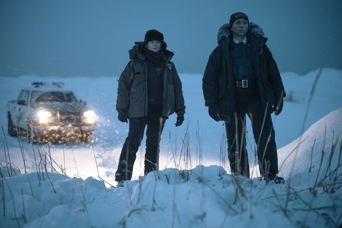 Les détectives de l'Alaska Liz Danvers et Evangeline Navarro se tiennent sur une colline enneigée devant leur camion d'escouade dans la série HBO True Detective : Night Country.