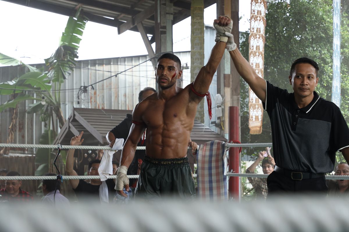 Nassim Lyes, l'air absolument déchiqueté, lève le bras sur le ring après un combat dans Mayhem !