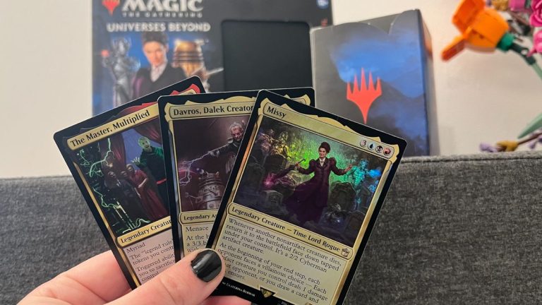 Three cards from Magic: The Gathering Doctor Who being held up in front of the Commander Deck box