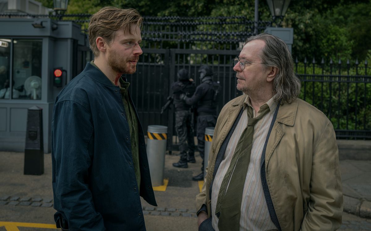 Jack Lowden et Gary Oldman discutent devant une zone sécurisée dans Slow Horses