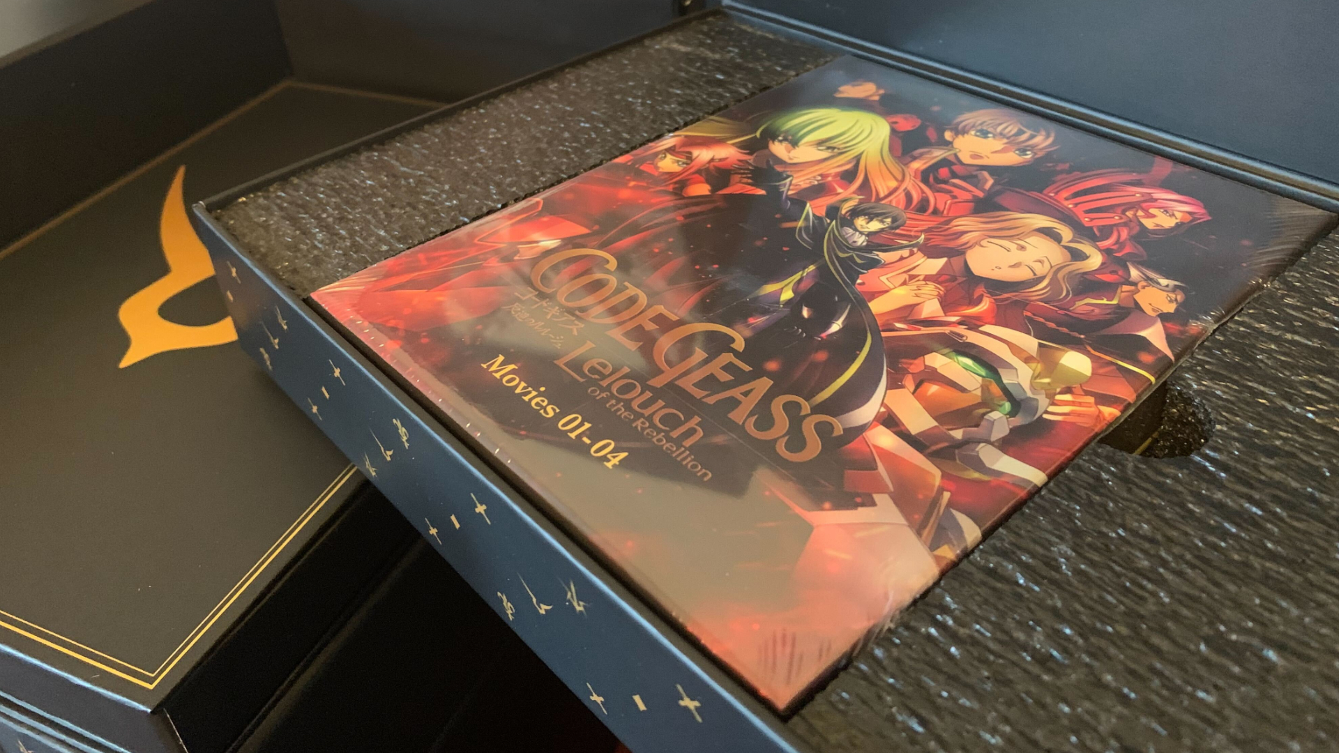 Édition collector de Code Geass avec une boîte de film dans un plateau rembourré