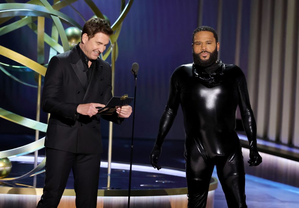 Dylan Mcdermott et Anthony Anderson aux Emmys 2023, Mcdermott rit alors qu'il tient l'enveloppe avec le nom du gagnant du meilleur acteur dans une série limitée dramatique, tandis qu'Anderson porte un costume d'homme en caoutchouc