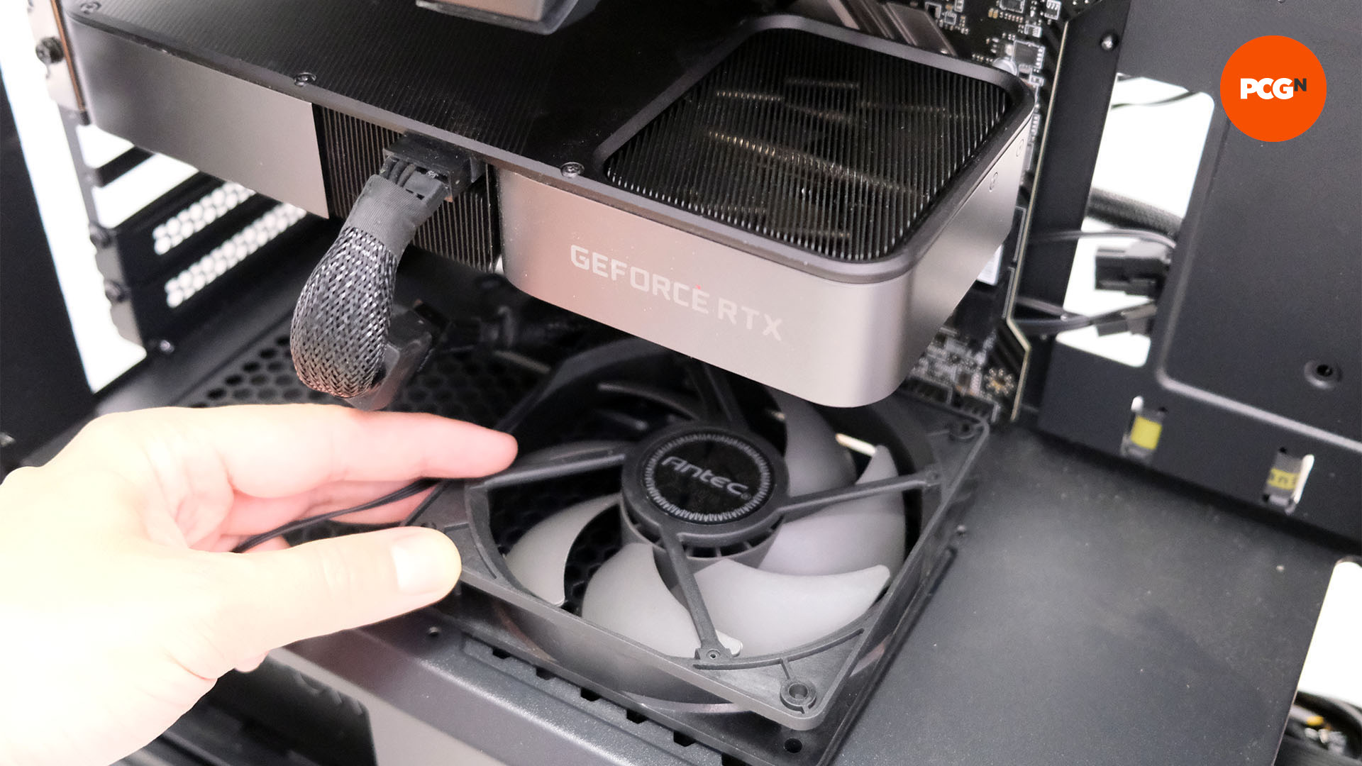 L'intérieur d'un boîtier PC où quelqu'un a monté un ventilateur PC au-dessus du carénage du bloc d'alimentation pointant vers le GPU