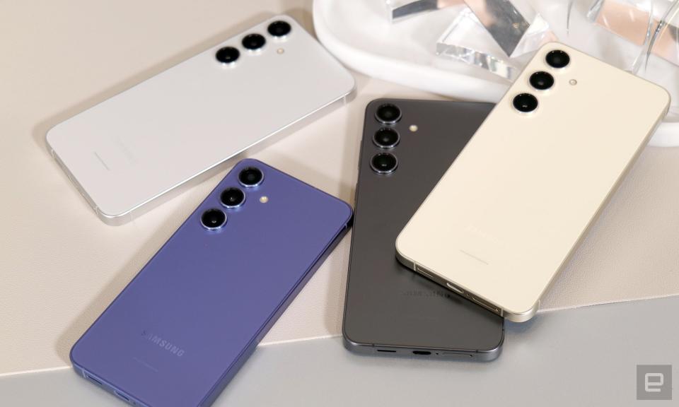 Quatre combinés Galaxy S24 en blanc, crème, noir et violet, posés sur une table avec leurs caméras arrière tournées vers le haut.