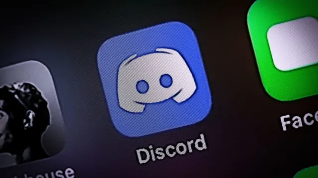 Gros plan sur l'icône Discord sur l'écran d'un téléphone, à côté de FaceTime.