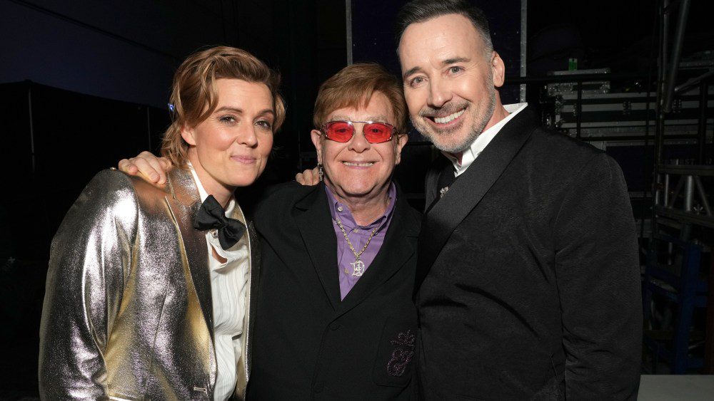 LOS ANGELES, CALIFORNIA - FEBRUARY 03: (L-R) Brandi Carlile, Elton John, and David Furnish attend MusiCares Persons of the Year Honoring Berry Gordy and Smokey Robinson at Los Angeles Convention Center on February 03, 2023 in Los Angeles, California. (Photo by Kevin Mazur/Getty Images for The Recording Academy)