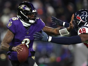 Lamar Jackson des Ravens de Baltimore, bras raides, Christian Harris des Texans de Houston au stade M&T Bank le 20 janvier 2024 à Baltimore, Maryland.