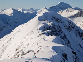 Les skieurs de l'arrière-pays se dirigent le long d'une crête de montagne près de McGillivray Pass Lodge, situé dans le sud des monts Chilcotin, en Colombie-Britannique, le mardi 10 janvier 2012. Les risques d'inondation et d'avalanche restent élevés sur toute la côte sud de la Colombie-Britannique, où une série de phénomènes atmosphériques Les rivières continuent d'apporter de fortes pluies ainsi que des températures anormalement chaudes dans la région.